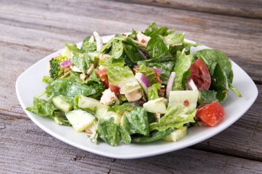 Tavuk ve sebze salatası ahşap arka üzerinde çiftlik sosu ile