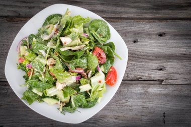 Tavuk ve sebze salatası ahşap arka üzerinde çiftlik sosu ile
