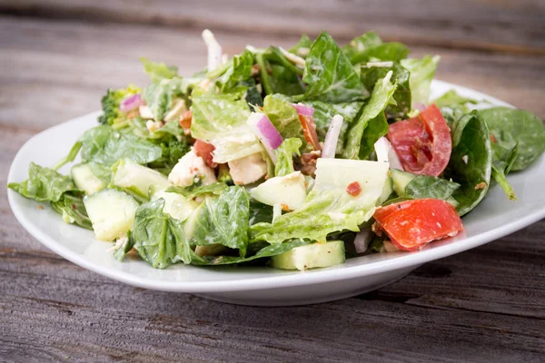 Ensalada de pollo y verduras con aderezo rancho sobre respaldo de madera —  Fotos de Stock