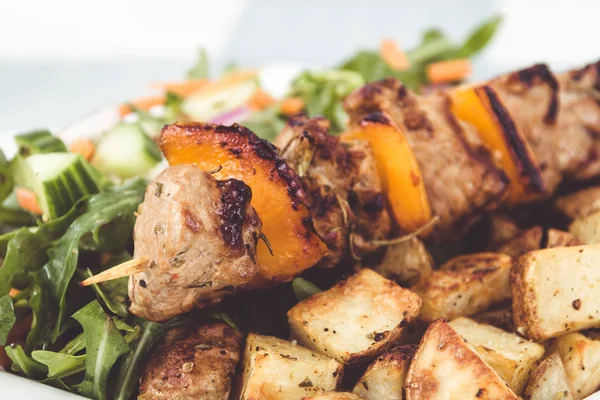 Plato de pincho de kebab de cerdo con papas y ensalada — Foto de Stock