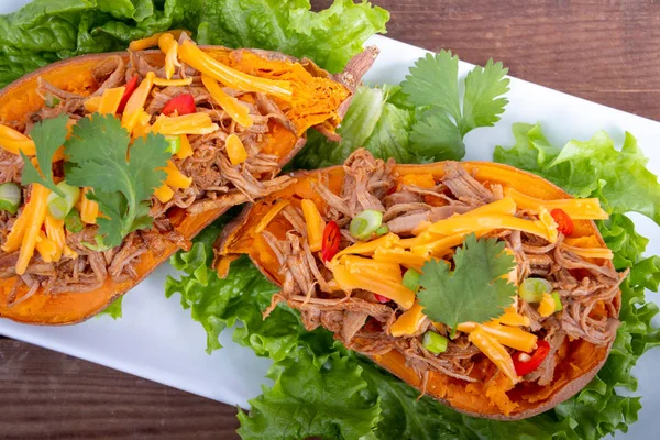 Delicious spicy pulled pork stuffed sweet potato dish — Stock Photo, Image