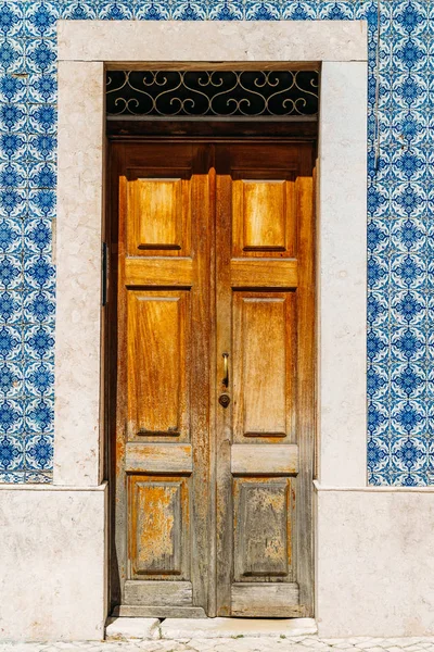 Antika ahşap kapı ile mavi mermer fayans duvar Lizbon, Portekiz — Stok fotoğraf