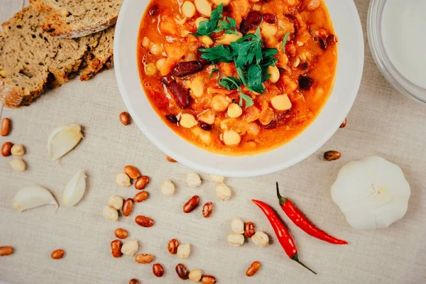 Acılı fasulye güveç, ekmek, kırmızı biber biber ve sarımsak hizmet için hazır