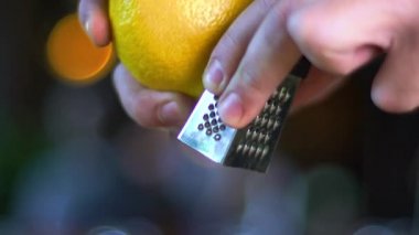 Birisi bir kokteylin içine limon kabuğu koyuyor. Barmen barda kokteyl hazırlıyor. Alkollü kokteyl yapma süreci. 