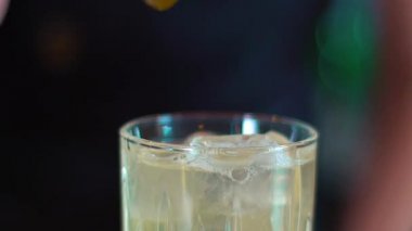 Birisi şu anda kokteyli dekore ediyor. Barmen barda kokteyl hazırlıyor. Alkolle kokteyl yapma süreci. makro kokteyl 