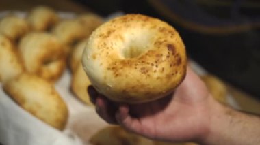 Güzel bir sepette taze ekmek. Birisi ekmeği bir kutuya koyuyor. Susamlı çörek. Kutuda susamlı susamlı çörek..