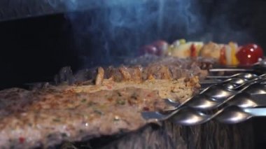 Birisi kebap pişiriyor. Şef bir et kebabı hazırlıyor. Şiş kebap kazıkta hazırlanıyor. Et kızardı. Yemek videosu yavaş çekim restoran mutfağını kapatıyor.. 