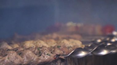 Birisi kebap pişiriyor. Şef bir et kebabı hazırlıyor. Şiş kebap kazıkta hazırlanıyor. Et kızardı. Yemek videosu yavaş çekim restoran mutfağını kapatıyor.. 