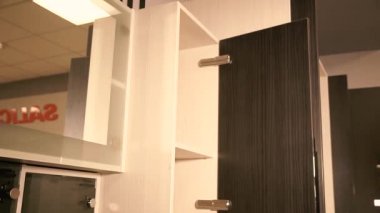 Bir adam duvar dolabını kapatır..