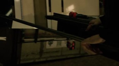 Üretim dolabı. Bir adam çekiçle cama vuruyor. Çekiçle çalış..