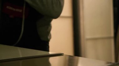 Üretim dolabı. Bir adam çekiçle cama vuruyor. Çekiçle çalış..