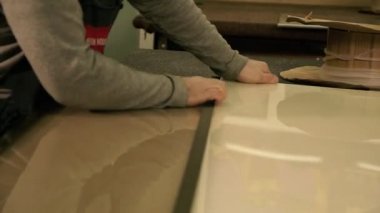 Üretim dolabı. Bir adam çekiçle cama vuruyor. Çekiçle çalış..