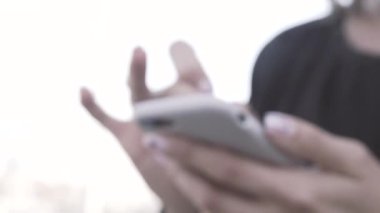 Sokakta bir kız duruyor. Telefonda bir kız var. Telefonu kız tutuyor..