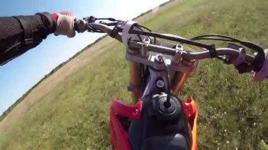 Adam ormanda tarlada motosiklet sürüyor. Tehlikeli motosiklet sürüşü.