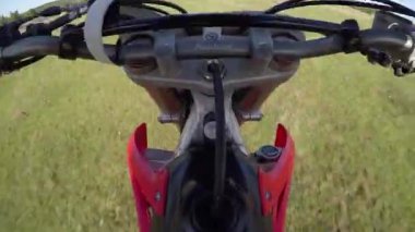 Adam ormanda tarlada motosiklet sürüyor. Tehlikeli motosiklet sürüşü.