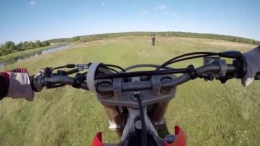 Adam ormanda tarlada motosiklet sürüyor. Tehlikeli motosiklet sürüşü.