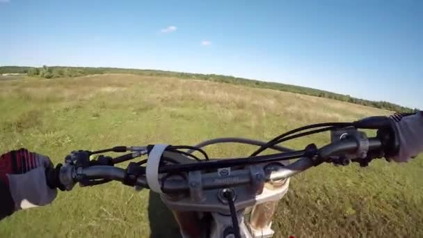 Killen åker motorcykel i skogen på fältet. Farlig motorcykelkörning. — Stockvideo