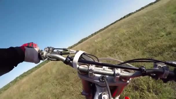 De man rijdt op een motor in het bos op het veld. Gevaarlijk motorrijden. — Stockvideo