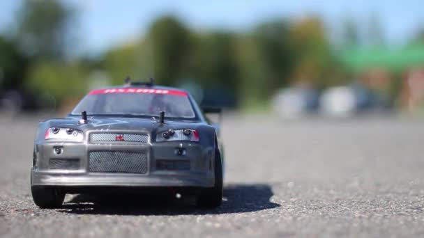 En liten bil rider på asfalt på sommaren — Stockvideo