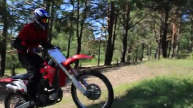 Adam kumda motosikletle geziyor..