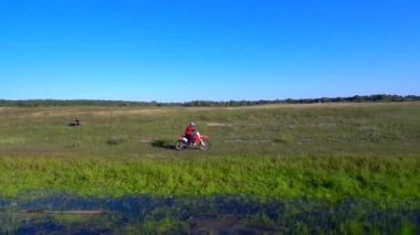 Adam yazın bir spor bisikleti sürüyor. Göl kenarında.