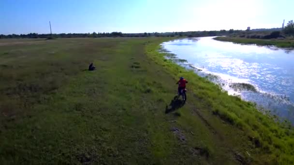 O tipo anda de bicicleta desportiva no Verão. Perto do lago — Vídeo de Stock