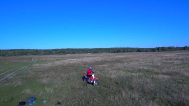 Adam yazın bir spor bisikleti sürüyor. Göl kenarında.