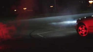 Asfaltta kırmızı ateş yanıyor. Arabanın yanında.