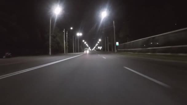 Автомобиль едет по дороге поздно ночью — стоковое видео