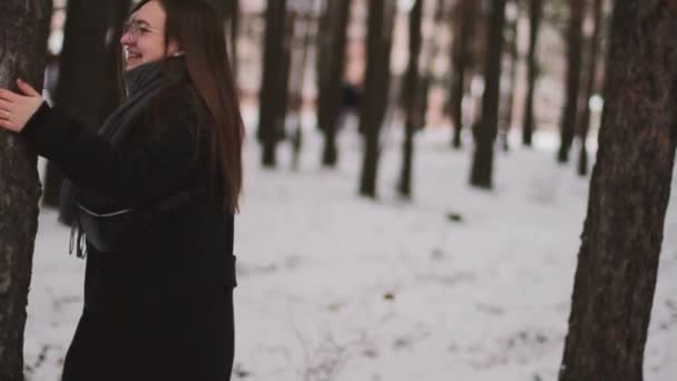 一个女孩在森林里散步。触摸雪。雪地里的森林。那姑娘玩得很开心. 图库视频片段