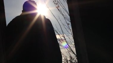 Adam terk edilmiş bir binadan geçiyor.