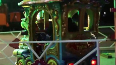 Eğlence parkı. Akşam eğlence parkı. Bir sürü parlak ampul. Parlak sürüşler
