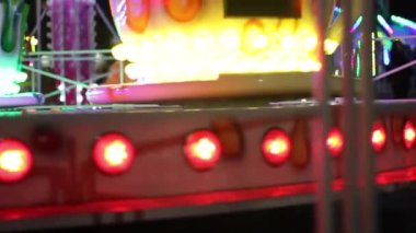 Eğlence parkı. Akşam eğlence parkı. Bir sürü parlak ampul. Parlak sürüşler