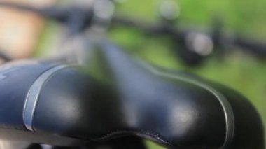 Bisiklet akşamleyin çimlerin üzerinde yatıyor. Bisikletin yakın çekimleri. Yeşil bisiklet.