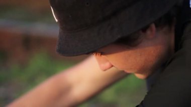 Adamın biri çimlerin üzerinde bir kuadrokopteri tamir ediyor..