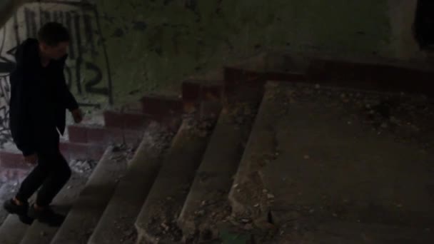 El tipo camina por un edificio abandonado — Vídeos de Stock