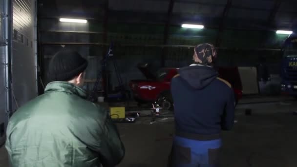 Chicos están reparando en un taller de reparación de coches . — Vídeo de stock