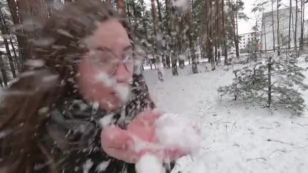 Rapariga a soprar na neve. Muita neve. Inverno na floresta . — Vídeo de Stock