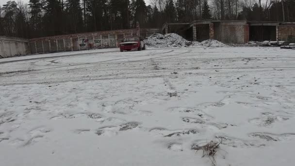 Un coche viejo se desplaza a lo largo de una carretera nevada. El invierno. Mucha nieve. . — Vídeo de stock