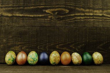 Paskalya yumurtaları arka arkaya koyu kahverengi ahşap arka planda, boşluğu kopyala