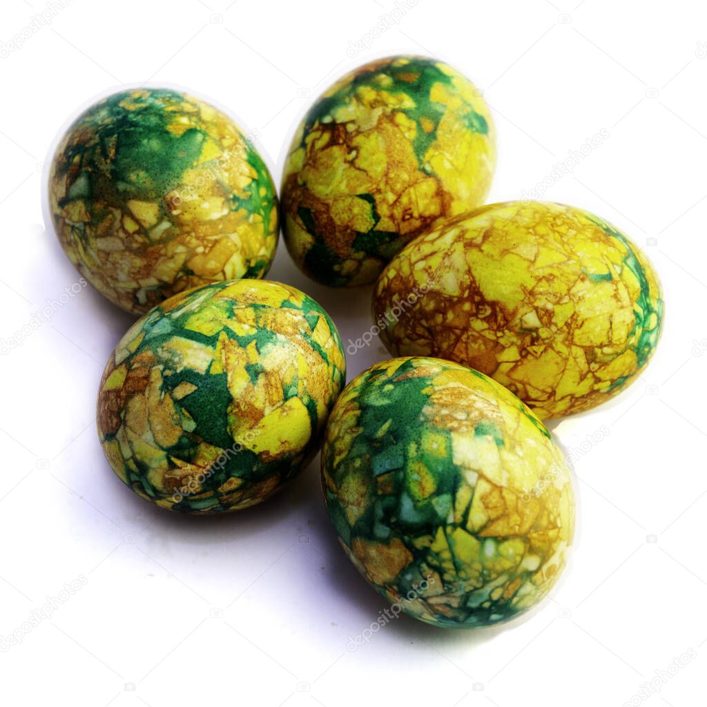 handmade yellow green easter eggs painted marbled over white background