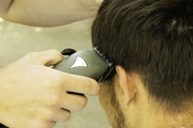 Bir berber adamı makasla keser.