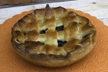 Elma reçeli, kiraz ve ceviz ağaçtan bir masada duran pastayı dolduruyor.