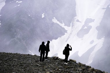 Turistler bir uçurumun tepesinde dururlar.