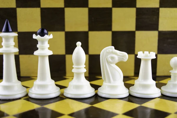 Piezas de ajedrez blanco de pie sobre el fondo de un tablero de ajedrez — Foto de Stock