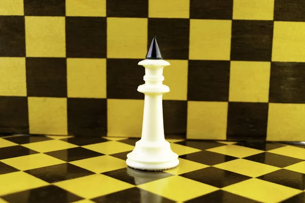 Rey de ajedrez blanco se levanta contra el fondo de un tablero de ajedrez —  Fotos de Stock