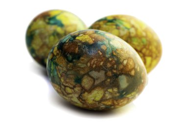 El yapımı sarı Paskalya yumurtaları. Beyaz arka planda mermer boyanmış.