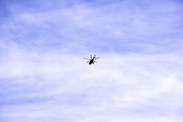 Вертолет летит против голубого неба и облаков — стоковое фото