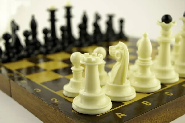 Piezas de ajedrez en blanco y negro de pie en un tablero de ajedrez antes del inicio de la partida — Foto de Stock