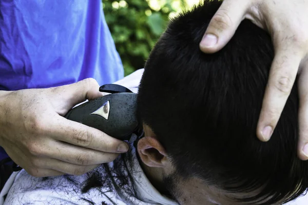 Un peluquero corta al tipo con un cortaplumas — Foto de Stock